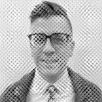 a black and white photo of a man wearing glasses and a tie