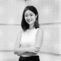 a black and white photo of a woman standing in front of a building